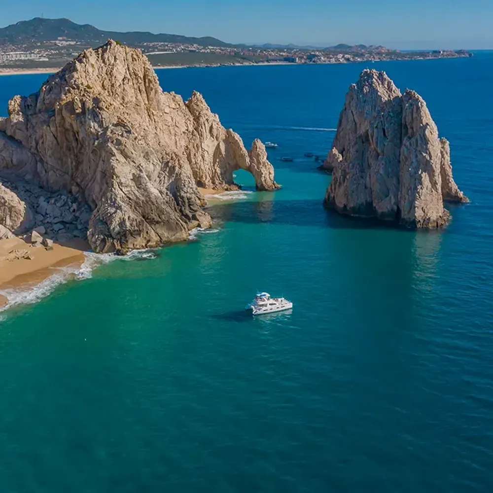 Aerial view of Land's End in Cabo San Lucas — the Arch and rock formations where the beach meets the Sea of Cortez